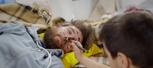 Mischievous boy painting face of father sleeping on couch at home Faule Eltern: Interview mit Hodkinson