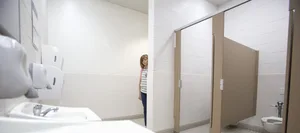 Schoolgirl A child peeks cautiously round the corner of a school toilet