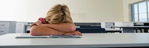 L_Gesellschaft_Schule_Schulangst_Junge_liegt_auf_Pult-scaled Wenn die Schulbank drückt