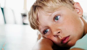 09_20_Verträumte_Kinder_Dossier_Hauptteil_HL Verträumte Kinder unter Druck: Bub legt Kopf auf den Pult und schaut gedankenverloren in die Ferne
