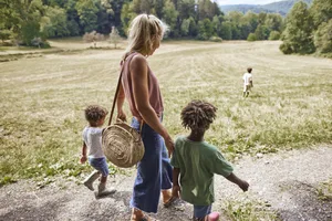 Mère avec ses enfants marchant sur un chemin rural Quelles sont les valeurs qui me tiennent à cœur ? Une mère avec ses trois enfants.