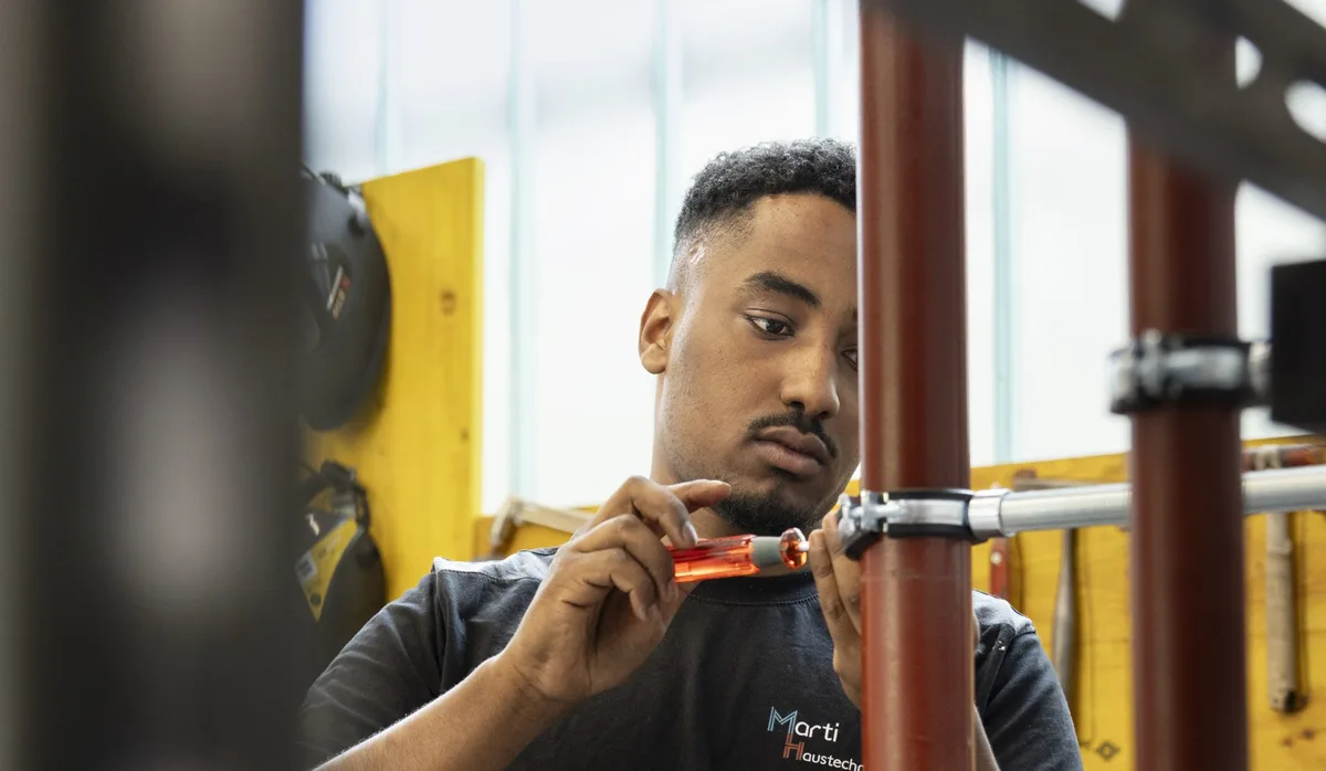 26-09-choix-de-métier-2026-Yonatan-Paulos-installateur de chauffage Un jeune homme dans l'atelier : formation d'installateur de chauffage CFC