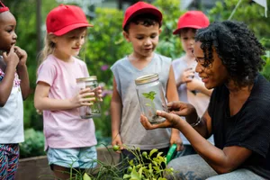 Insegnanti e bambini: apprendimento scolastico ed ecologia del giardinaggio Insegnante con bambini nell'orto scolastico
