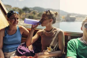 A mother and her teenage children waiting for the ferry to set off. Wife and stepchildren on a ship