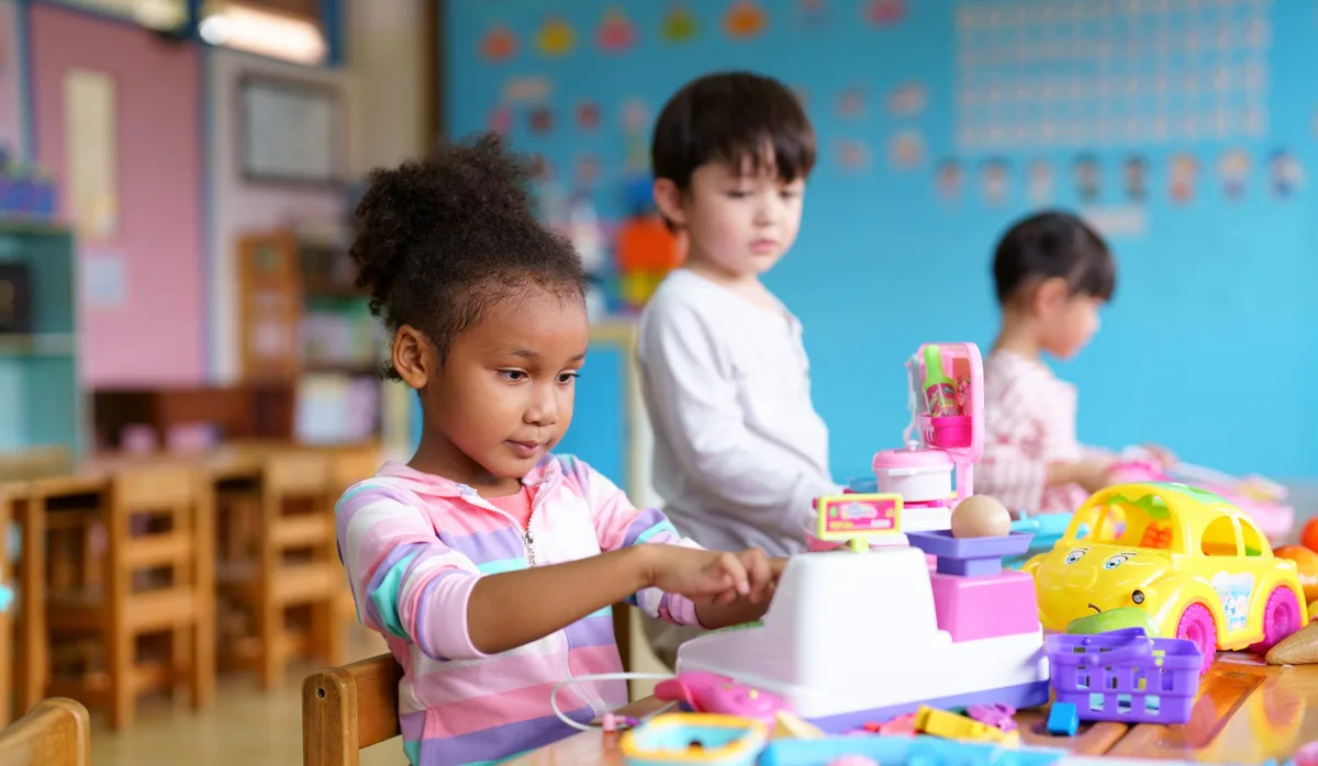 Children playing together in playroom Mädchen im Kindergarten ins Spiel vertieft