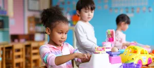 Children playing together in playroom Mädchen im Kindergarten ins Spiel vertieft