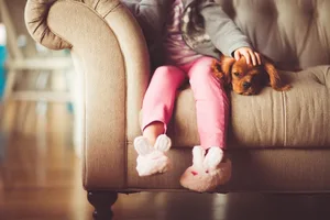 Header_Chiens_en_santé_pour_les_enfants Un enfant et un adorable chien sont assis sur le canapé. Les chiens font du bien aux enfants.