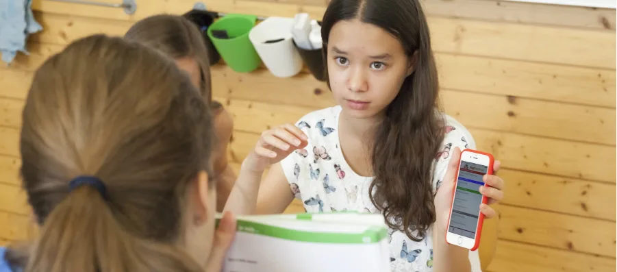 École numérique-fille-travaille-sur-smartphone-HL La numérisation des écoles suisses