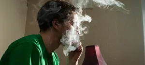 Sabine_Dobler_Intervista-L-1 Il ragazzo si siede sul letto e fuma erba